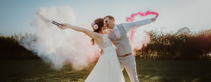 bride and groom holding flares 